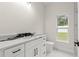 Modern bathroom featuring a stylish vanity with sleek black fixtures, tile floors and a large window at 10262 Maybird Ave, Weeki Wachee, FL 34613