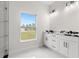 Modern bathroom featuring a marble-style vanity, tile flooring, and natural light at 10262 Maybird Ave, Weeki Wachee, FL 34613