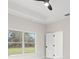 Bright bedroom featuring white tile flooring, natural light, and a ceiling fan at 10262 Maybird Ave, Weeki Wachee, FL 34613