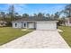 Charming single-story home with a paved driveway, attached garage, and well-manicured lawn at 10262 Maybird Ave, Weeki Wachee, FL 34613