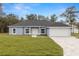 Charming single-story home with a paved driveway, attached garage, and well-manicured lawn at 10262 Maybird Ave, Weeki Wachee, FL 34613