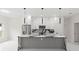 Modern kitchen with stainless steel appliances and a large gray island with marble countertops at 10262 Maybird Ave, Weeki Wachee, FL 34613