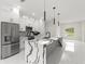 Modern kitchen featuring white cabinets, stainless steel appliances, and a striking waterfall island countertop at 10262 Maybird Ave, Weeki Wachee, FL 34613
