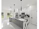 Spacious open-concept kitchen with stainless steel appliances, pendant lighting, and white cabinetry at 10262 Maybird Ave, Weeki Wachee, FL 34613