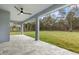 Covered patio offers an outdoor living space with a ceiling fan and serene views of the backyard at 10262 Maybird Ave, Weeki Wachee, FL 34613