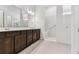Well-lit bathroom featuring a double vanity, a walk-in shower, and a clean, modern design at 11423 Shoreline Trl, Parrish, FL 34219