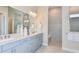 Elegant bathroom with dual sinks, granite countertops, modern fixtures, and a spacious walk-in shower with neutral tile at 11423 Shoreline Trl, Parrish, FL 34219