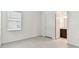 Bedroom with neutral walls, trim, window, and an open door to the bathroom at 11423 Shoreline Trl, Parrish, FL 34219