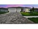 Charming single-story home featuring a three-car garage, paved driveway, and beautifully landscaped front yard at 11423 Shoreline Trl, Parrish, FL 34219