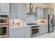 Modern kitchen with stainless steel appliances, gray cabinetry, sleek hardware, and a stylish backsplash, all under recessed lighting at 11423 Shoreline Trl, Parrish, FL 34219