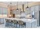Elegant kitchen showcasing gray cabinets, stainless steel appliances, a large island with seating, and modern pendant lighting at 11423 Shoreline Trl, Parrish, FL 34219