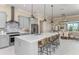 Stylish kitchen featuring gray cabinetry, a center island with seating, stainless steel appliances, and a mosaic backsplash at 11423 Shoreline Trl, Parrish, FL 34219