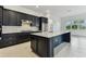 Modern kitchen features an expansive island, stainless appliances, and sleek dark cabinetry at 11423 Shoreline Trl, Parrish, FL 34219