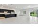 Open-concept living space with tiled floors, large windows, and a modern kitchen island at 11423 Shoreline Trl, Parrish, FL 34219