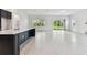 Open-concept living space with tile flooring, large windows, and a modern kitchen island at 11423 Shoreline Trl, Parrish, FL 34219