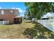 Spacious, fenced backyard featuring a screened lanai, shade trees, and space for outdoor activities at 11449 Crestlake Village Dr, Riverview, FL 33569