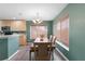 Bright dining area with wood table and chairs, chandelier, and natural light from the window, adjacent to the kitchen at 11449 Crestlake Village Dr, Riverview, FL 33569
