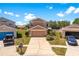 Two-story house with neutral paint, two-car garage and front yard with flower beds at 11449 Crestlake Village Dr, Riverview, FL 33569