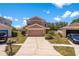 Two-story house with neutral paint, two-car garage and front yard with flower beds at 11449 Crestlake Village Dr, Riverview, FL 33569