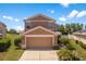 Two-story home with a two car garage and landscaped front yard on a sunny day at 11449 Crestlake Village Dr, Riverview, FL 33569