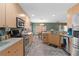 Fully equipped kitchen with stainless steel appliances, light wood cabinetry, and view into adjacent dining area at 11449 Crestlake Village Dr, Riverview, FL 33569