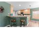 Kitchen bar with stools, light wood cabinets, and a view into the kitchen area, perfect for casual dining at 11449 Crestlake Village Dr, Riverview, FL 33569