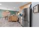 Well-equipped kitchen with stainless steel refrigerator, light wood cabinets, and view into the dining area at 11449 Crestlake Village Dr, Riverview, FL 33569