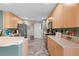 Well-lit kitchen with wood cabinets, gray tile flooring, and stainless steel appliances at 11449 Crestlake Village Dr, Riverview, FL 33569