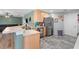 Modern kitchen featuring stainless steel appliances, light wood cabinetry, and stylish gray tile flooring at 11449 Crestlake Village Dr, Riverview, FL 33569
