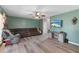 Well-lit living room featuring new laminate floors, a ceiling fan, a TV, and comfortable seating at 11449 Crestlake Village Dr, Riverview, FL 33569
