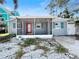 Exterior view of the home's front porch with light-filled windows and a red front door at 1214 Bay Shore Blvd, Indian Rocks Beach, FL 33785
