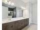 Bathroom featuring a double sink vanity with dark wood cabinets and a tiled shower, exuding luxury at 13052 Homestead Ln, Parrish, FL 34219