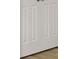 A close-up of a white interior door with recessed panels and wood-style flooring below at 13052 Homestead Ln, Parrish, FL 34219