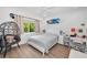 Bright bedroom with a queen bed, a surfboard on the wall, and a hanging chair with a teddy bear at 15229 Wind Whisper Dr, Odessa, FL 33556