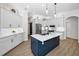 Modern kitchen with white cabinetry, stainless steel appliances, a subway tile backsplash and a center island with a blue base at 15229 Wind Whisper Dr, Odessa, FL 33556