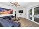 Cozy living room with a large sectional, sleek built-ins, and glass doors leading to the pool area at 15229 Wind Whisper Dr, Odessa, FL 33556
