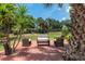 Outdoor seating arrangement on a wooden deck surrounded by lush tropical palm trees in a backyard at 1628 12Th Sw St, Largo, FL 33778