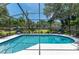 Screened pool with lounge chairs offers a private backyard oasis with tropical landscaping at 1628 12Th Sw St, Largo, FL 33778