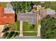 Aerial view of a well-maintained home with a manicured lawn, driveway, and surrounding trees at 1648 Arbor Dr, Clearwater, FL 33756