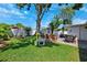 Lush backyard featuring a swing set, seating area, and ample green space for outdoor enjoyment at 1648 Arbor Dr, Clearwater, FL 33756