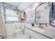 The bathroom features blue floral wallpaper, a plant, and a white marbled counter at 1648 Arbor Dr, Clearwater, FL 33756