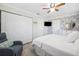 This bedroom features a ceiling fan, closet, a flat screen TV, and stylish wallpaper at 1648 Arbor Dr, Clearwater, FL 33756