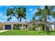 Charming home features a manicured lawn, painted exterior, and lush tropical landscaping at 1648 Arbor Dr, Clearwater, FL 33756
