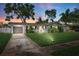 Charming home features a manicured lawn, painted exterior, and lush tropical landscaping at 1648 Arbor Dr, Clearwater, FL 33756