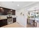 Kitchen featuring dark wood cabinets and stainless steel appliances, with an adjacent dining area at 1648 Arbor Dr, Clearwater, FL 33756