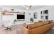 Living room featuring a leather sectional sofa, floating shelves, and light-colored flooring at 1648 Arbor Dr, Clearwater, FL 33756