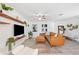 Bright living room with a leather sectional sofa, wood shelves, and a ceiling fan at 1648 Arbor Dr, Clearwater, FL 33756