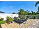 The backyard features lounge chairs on a stone patio, along with lush landscaping and a privacy fence at 1704 Via Palermo St, Plant City, FL 33566