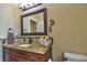 Well-lit bathroom with granite countertop, cherry wood vanity, and decorative backsplash at 1704 Via Palermo St, Plant City, FL 33566