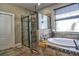 Bathroom featuring a walk-in shower, tub, and a modern window at 1704 Via Palermo St, Plant City, FL 33566